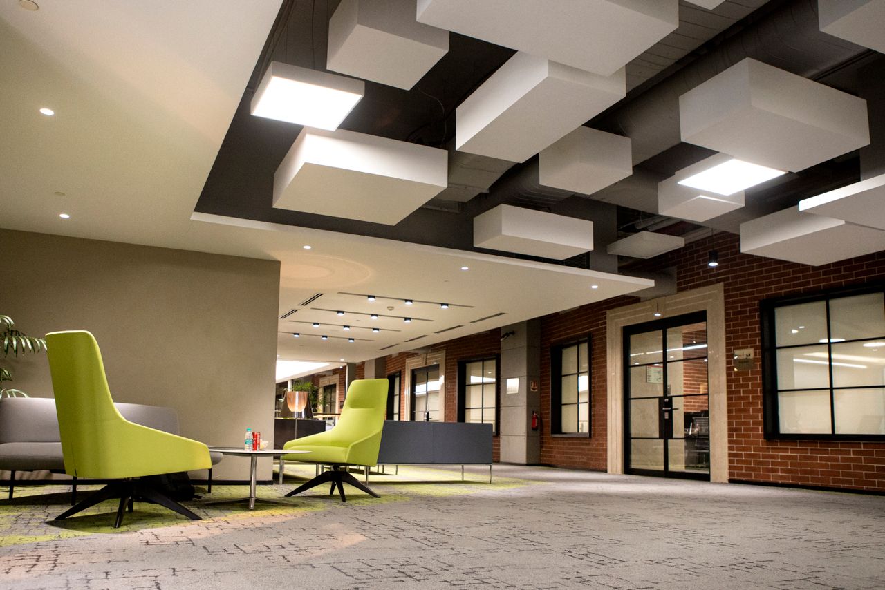 about-us-02 Contemporary office space featuring brick walls and unique ceiling design with bright lighting.